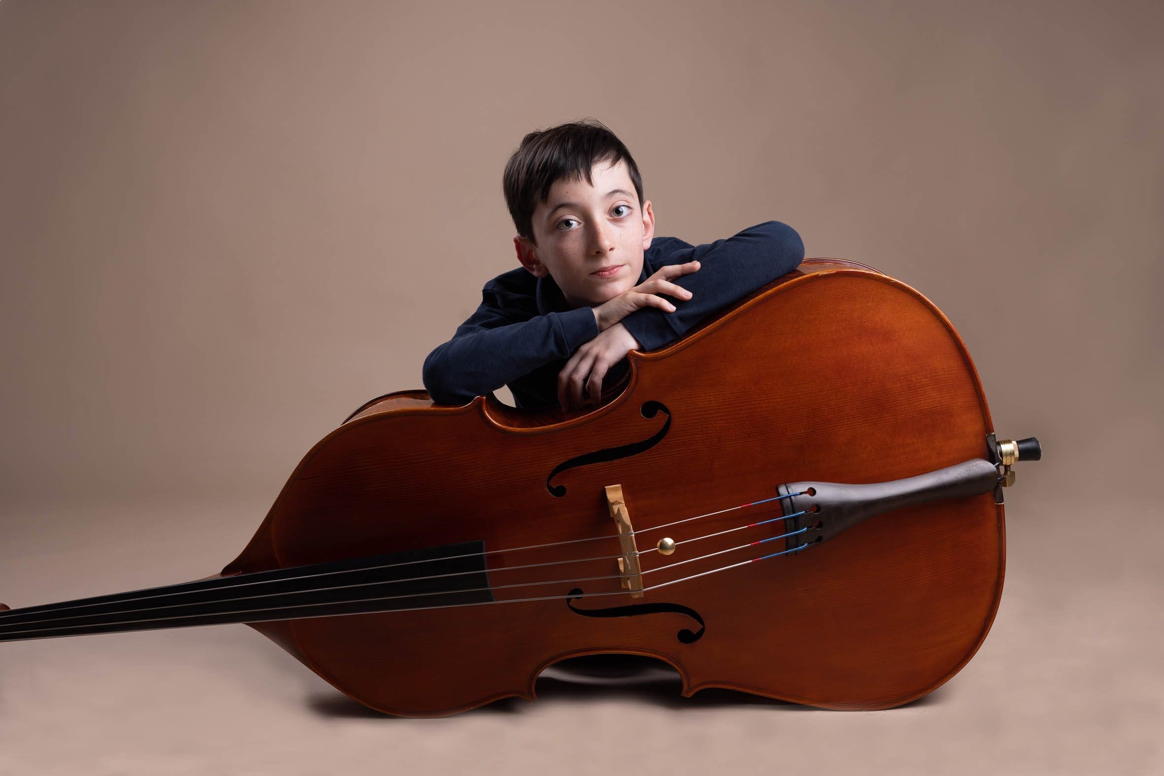 Jeune musicien avec violoncelle portrait studio