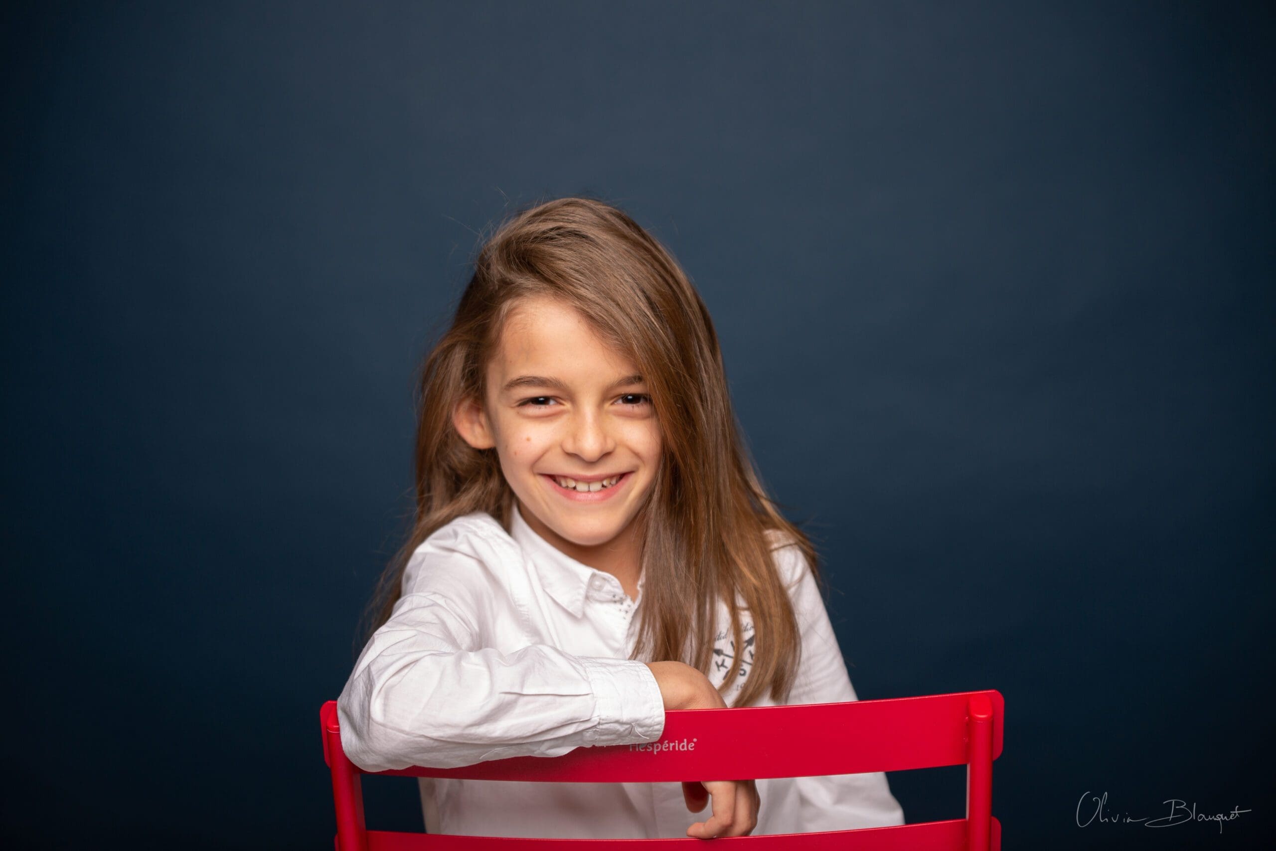 Petit garçon posant sur une chaise rouge, photographie enfant Nice.