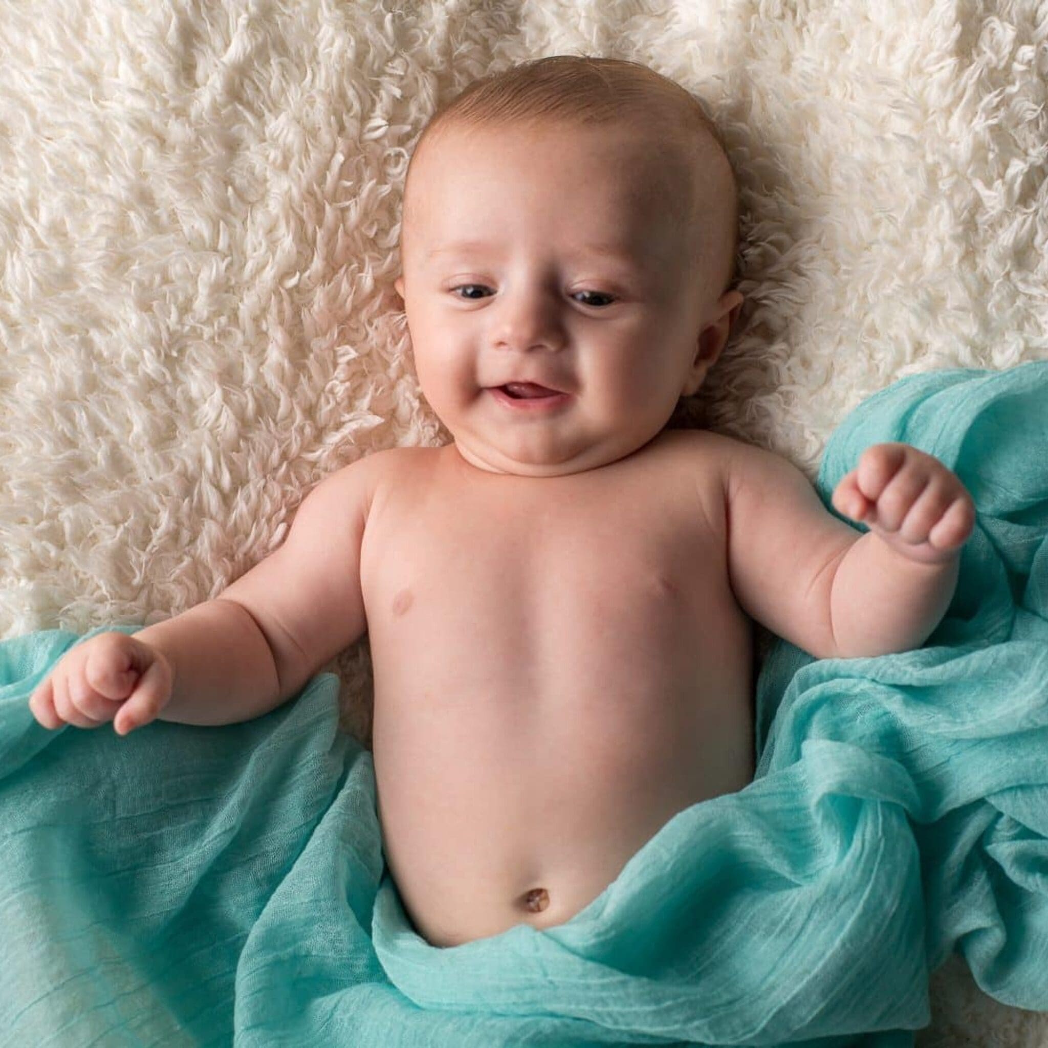 Portait nouveau-né allongé avec drap bleu texturé